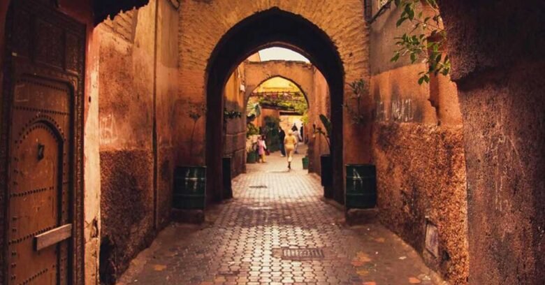 Une ruelle étroite avec des arches et une porte dans la médina, la vieille ville de Marrakech